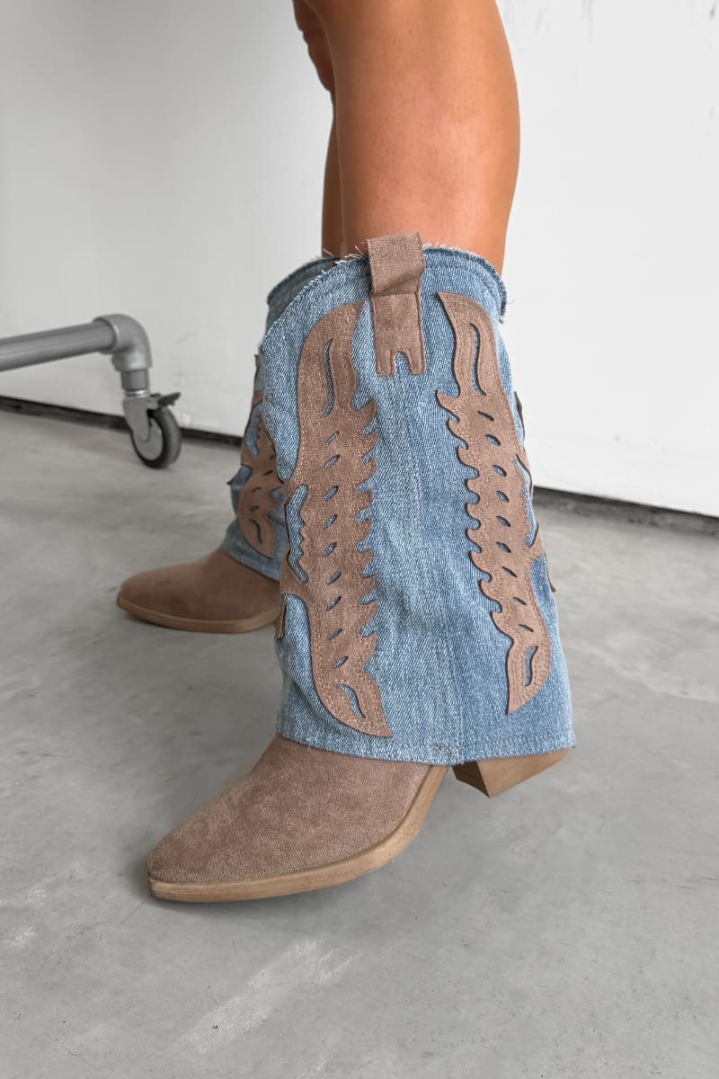 Denim cowboy boots with brown decorative elements worn by a person on a concrete floor. ADA Flared Cowboy Western Boots - Denim/Beige.
