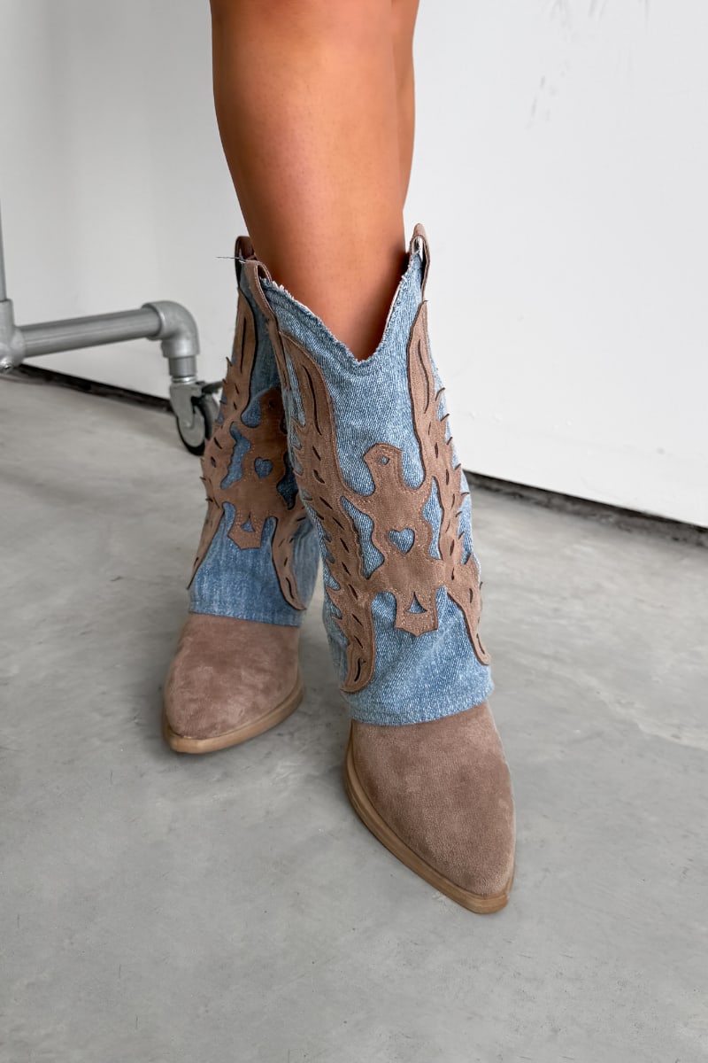 Brown cowboy boots with decorative cut-out design on a concrete floor.