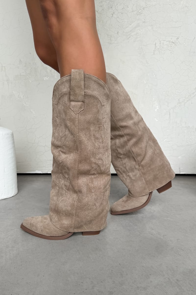 Beige suede knee-high boots on a neutral background