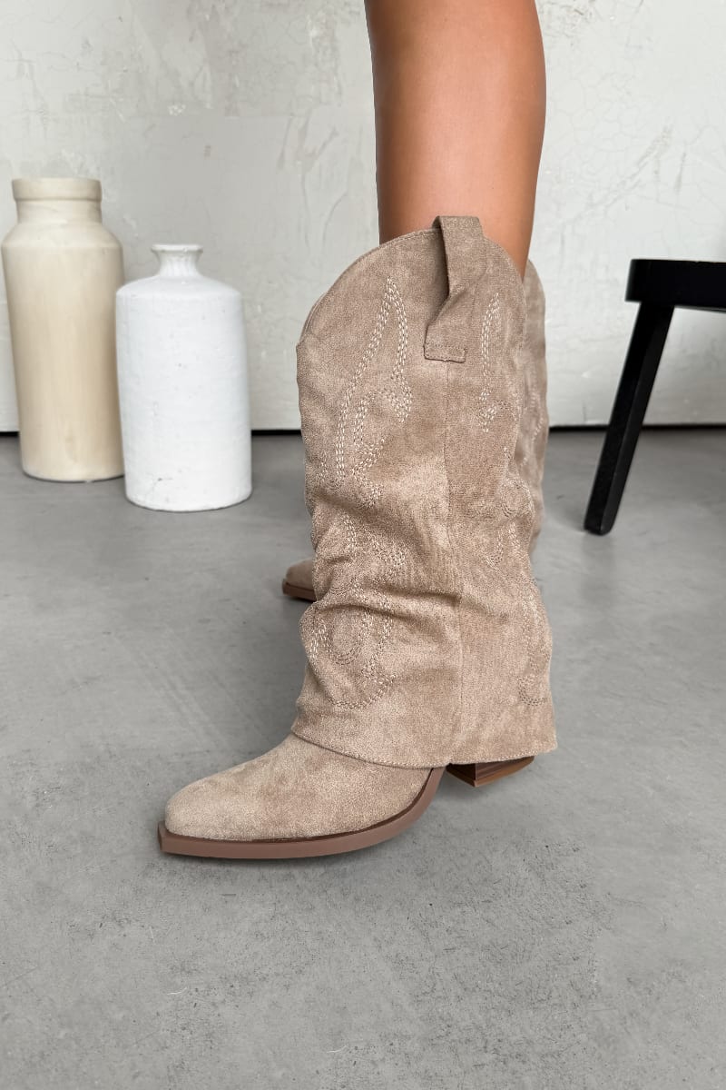 Beige suede knee-high boots on a neutral background