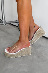 Person wearing beige platform sandals on a concrete floor. SOFIA Espadrille Wedge Perspex Sandals - White