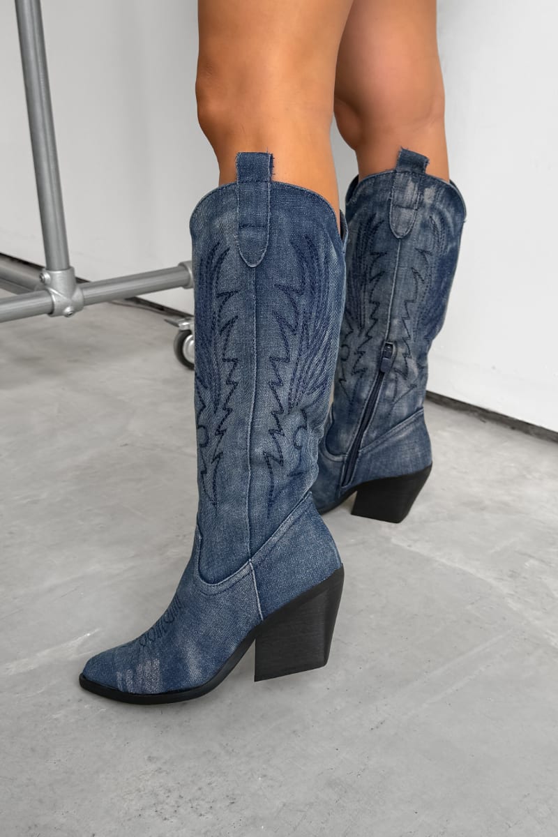 Blue cowboy boots worn by a person on a white background. TENNESSEE Knee High Cowboy Western Boots - Dark Denim - 3