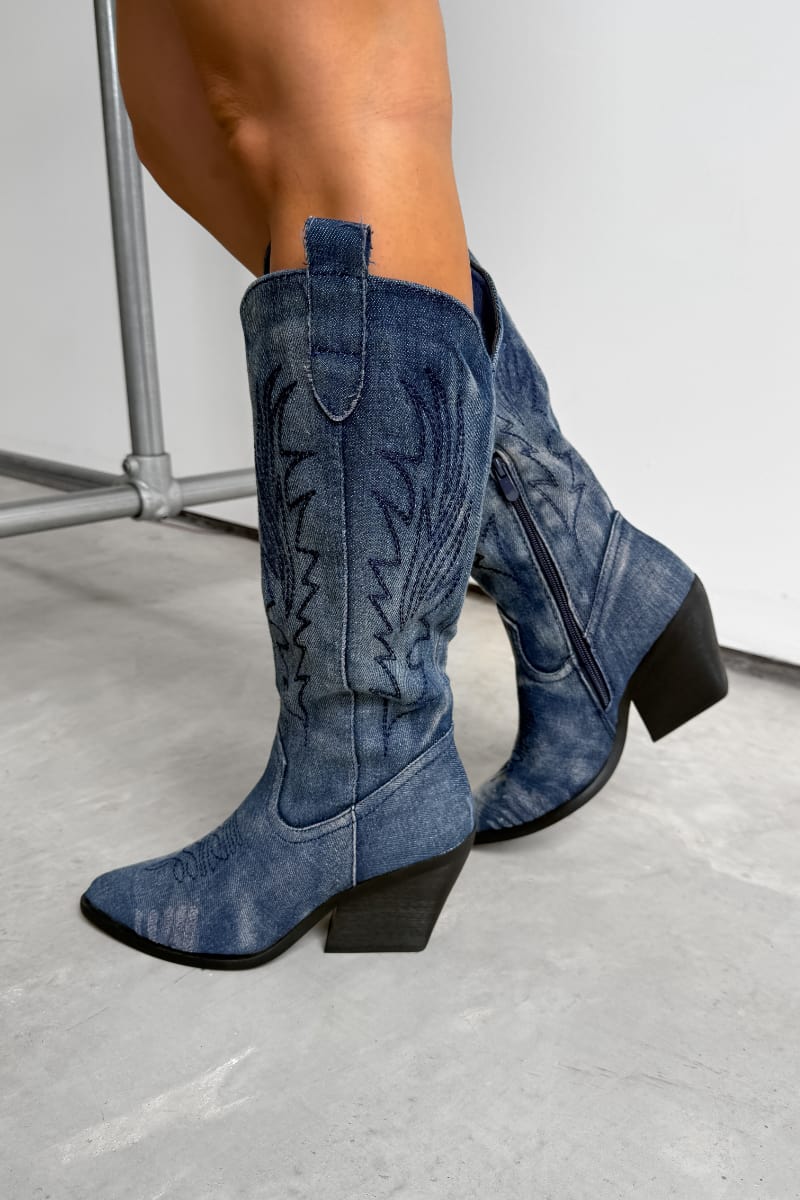 Blue cowboy boots worn by a person on a white background. TENNESSEE Knee High Cowboy Western Boots - Dark Denim - 1